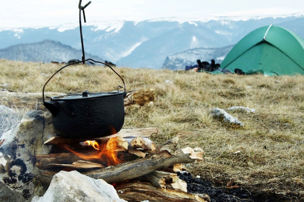 A campfire positioned away from a tent