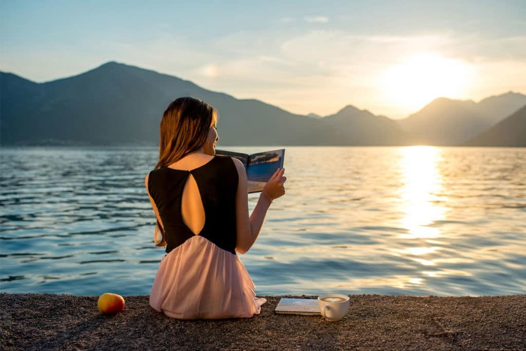 how to improve your vocabulary: woman reading by the water