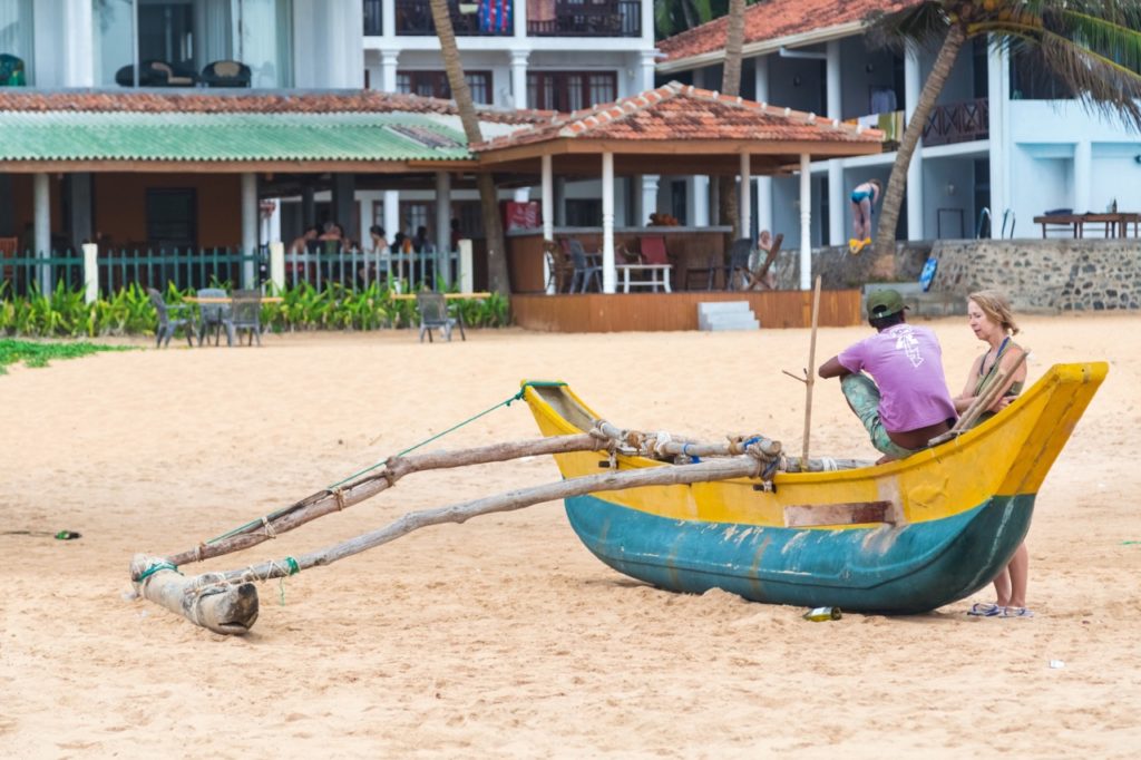 travel skills: western woman talking to a local boatman