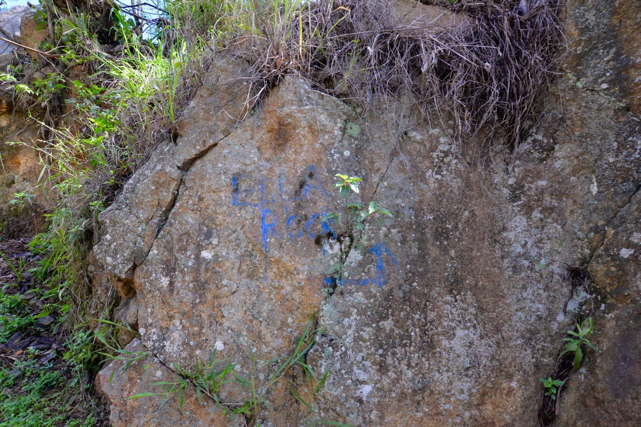 Blue graffiti pointing way to Ella Rock