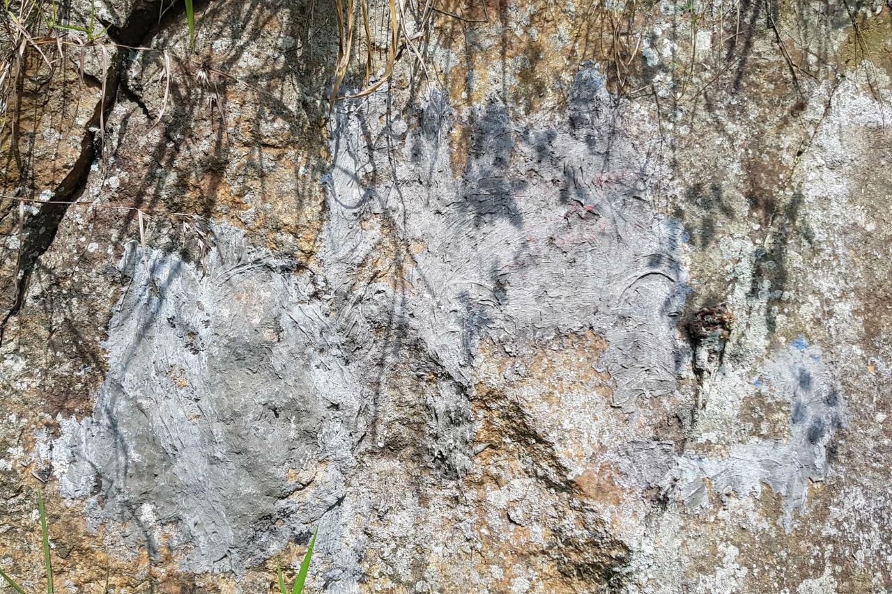 Photo of a rock with cement covering the marker