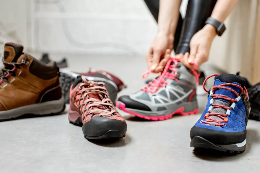 Mencoba sepatu hiking di toko