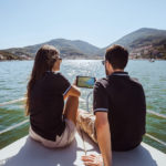a couple using a sailing app on a device while sailing