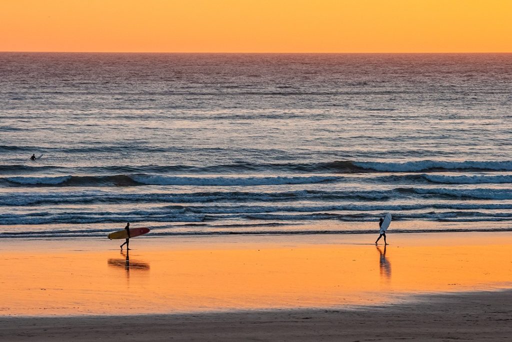 Surfers stroll on a Devon beach is one of our favourite outdoor destinations in Britain