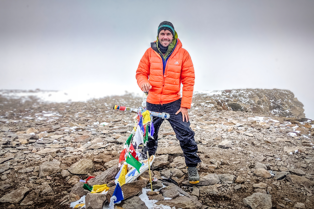 Peter on the summit of Aconcagua in an orange down jacket