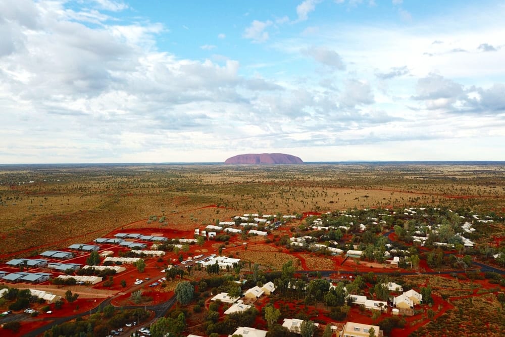 An aerial view of Yulara with Uluru in the background