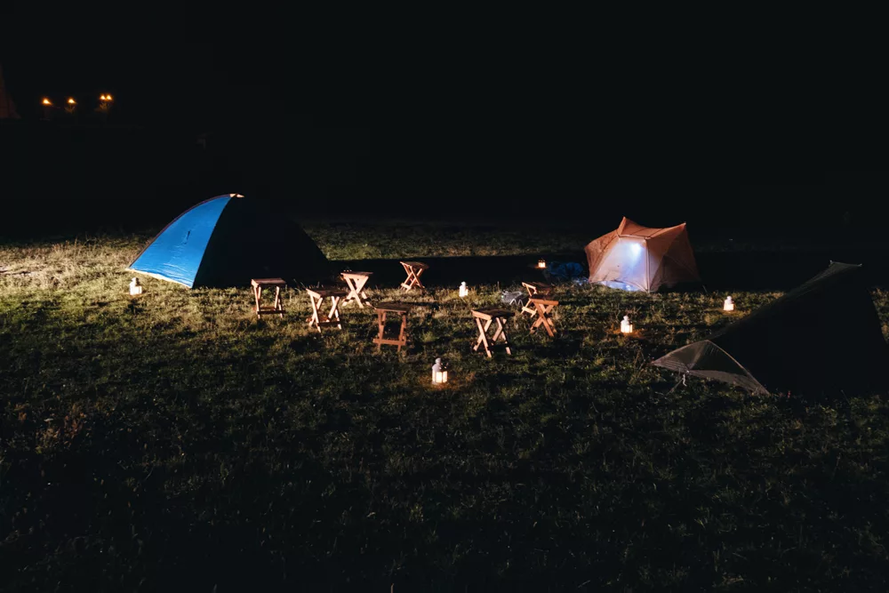 tents surrounded by small lights at night