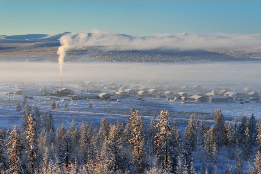 Oymyakon amid a frozen landscape with a forest in the foreground