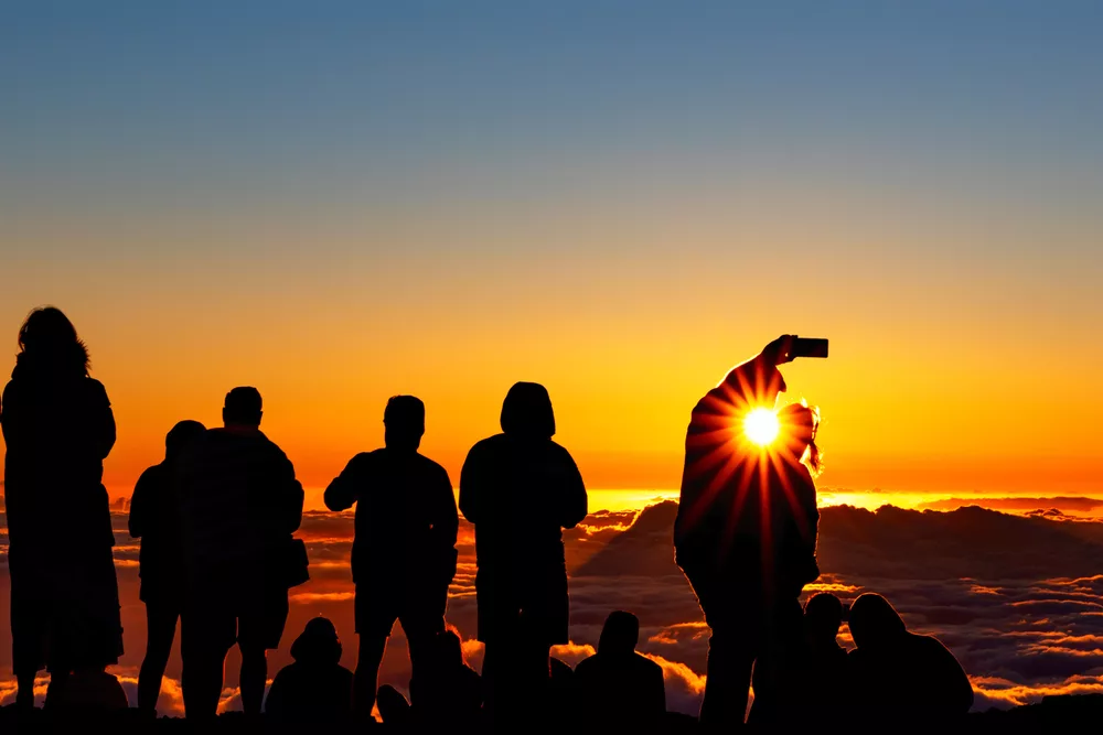 Silhouette of crowd enjoying the sunset atop Mount Haleakala on Maui, Hawaii