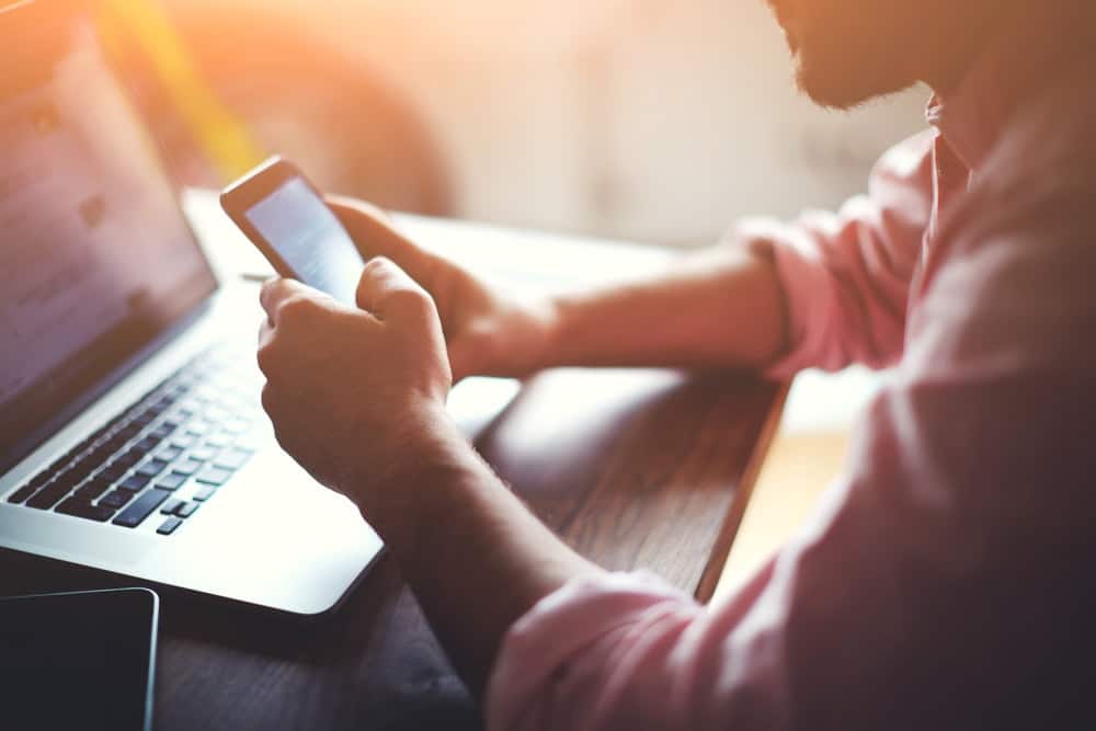 Person using a mobile phone and laptop