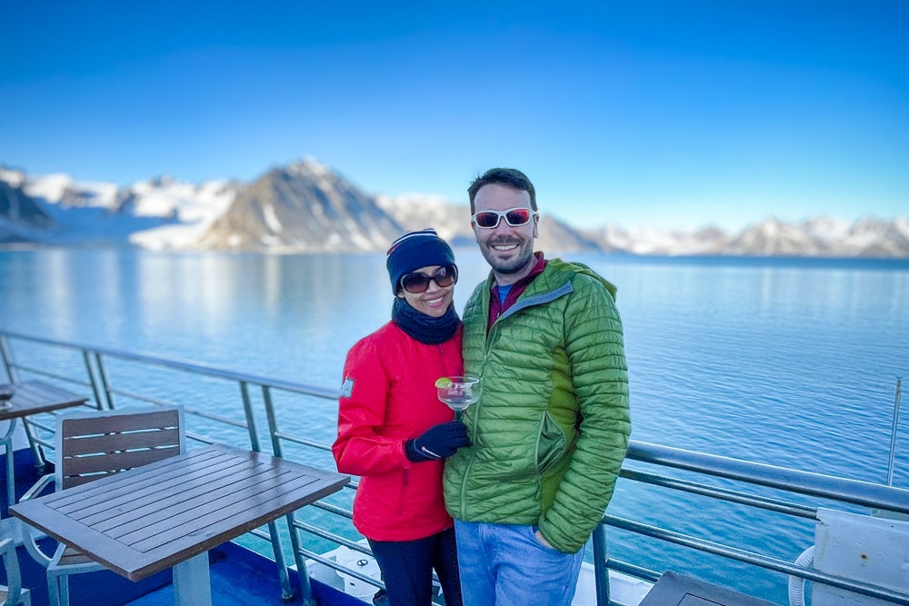 Peter and Kia drinking cocktails at midnight in sunshine – one of the reasons to visit Svalbard