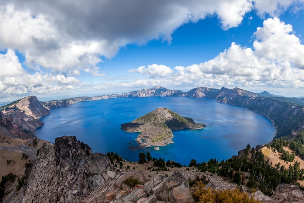Crater Lake and Wizard Island from Watchman Tower on the Western rim with white fluffy clouds in late summer