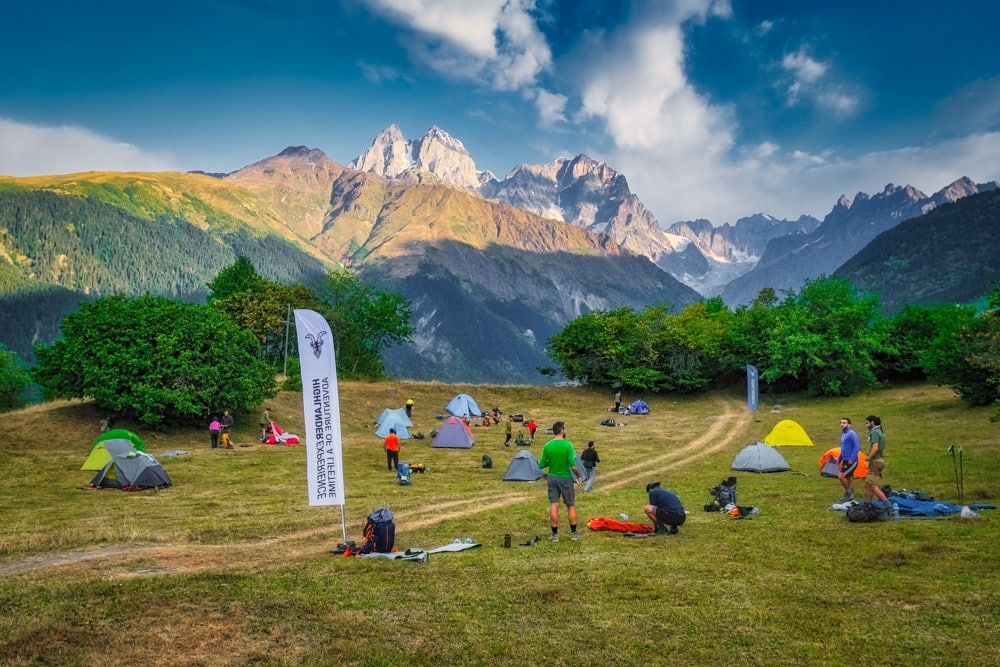 Campers on open ground with Mt Ushba in the background