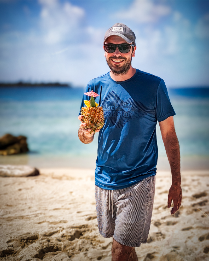 Peter holding a cocktail on Isla Pelícano in the San Blas Islands