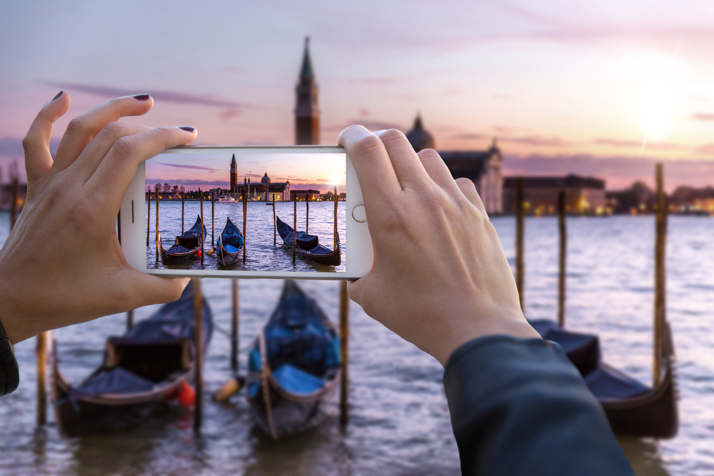 A traveller taking a photo in Venice while using an eSIM for travel in Europe