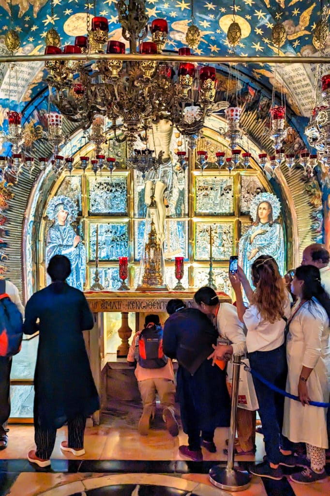 Pilgrims touch the Rock of Calvary