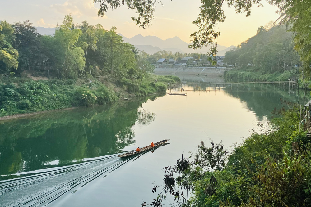 A canoe on a river with two Buddhist monks in Laos
