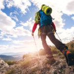 A trekker using poles uphill on a mountain
