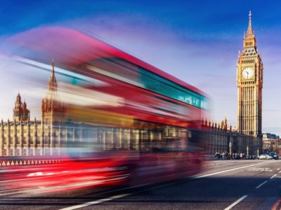 A city of London bus crosses a bridge in fron of Big Ben