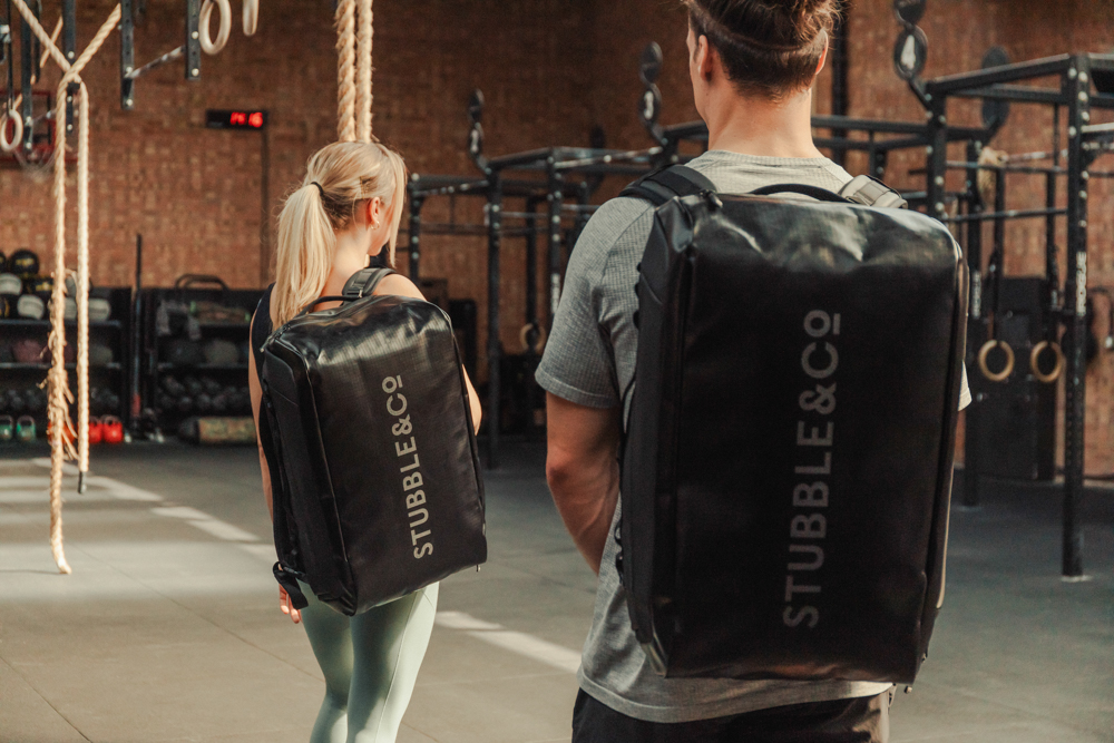 A man and woman using the sports bag Christmas gift in the gym