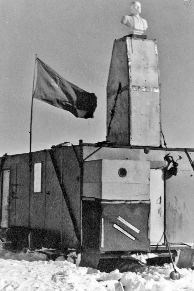 A B&W photo of the Lenin bust on top of the hut