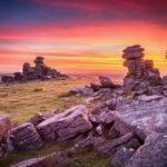 A vibrant sunset over staple tor in Dartmoor National Park