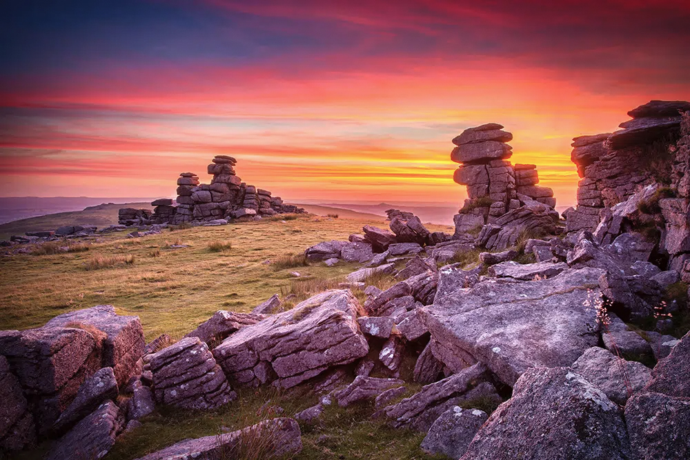 A vibrant sunset over staple tor in Dartmoor National Park