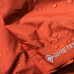 A close up of water droplets on a red Gore-tex waterproof jacket