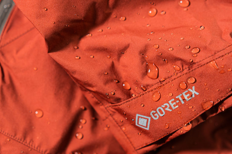 A close up of water droplets on a red Gore-tex waterproof jacket