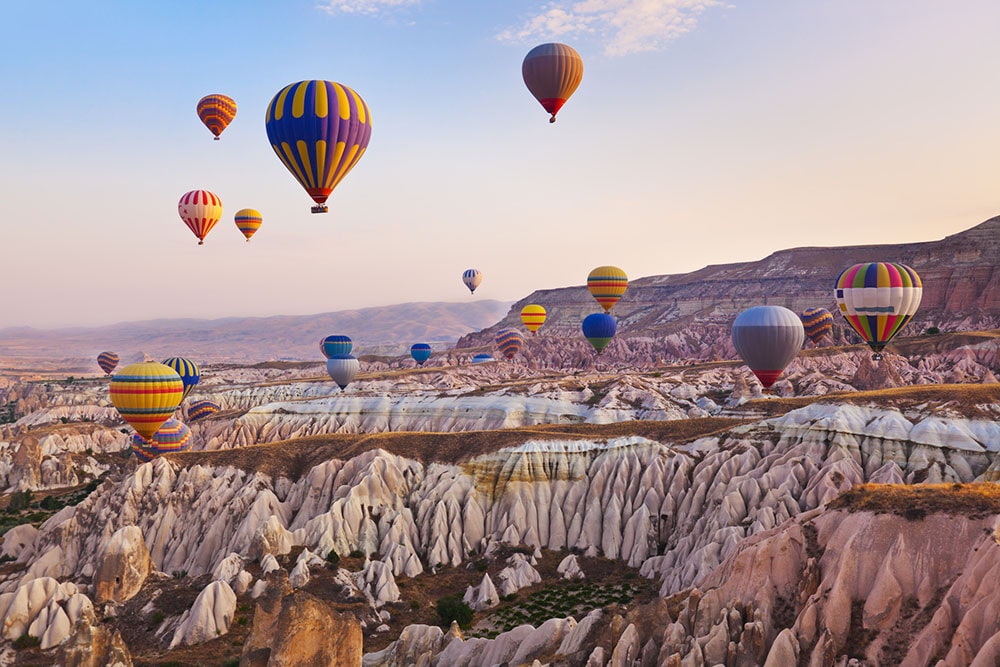 Hot air balloons flying over Cappadocia at sunrise