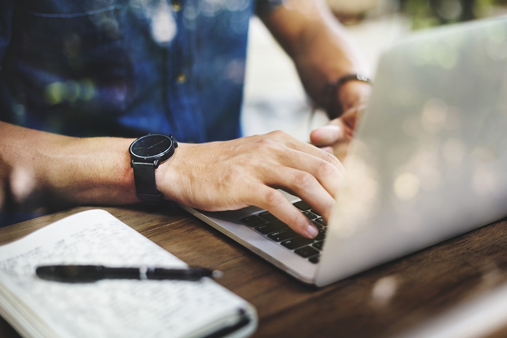 a digital nomad working at a laptop on a desk